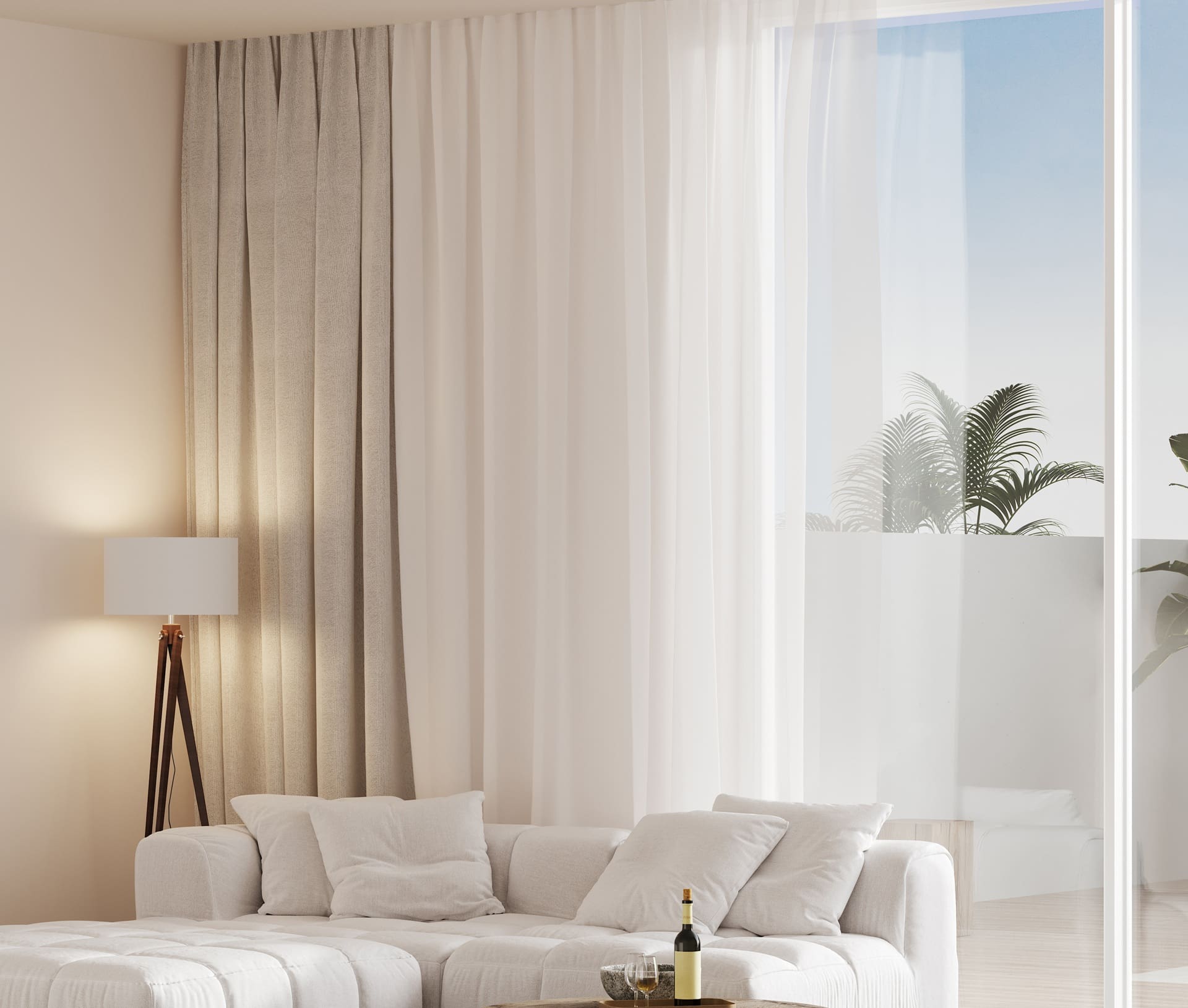 Modern living room with a white sofa, floor lamp, wine bottle on the ottoman, large sheer curtains, and glass doors opening to a balcony with plants.